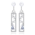 Long pearl-style drop earrings with decorated bar