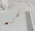 Gold-tone chain necklace with red heart pendant and pearl
