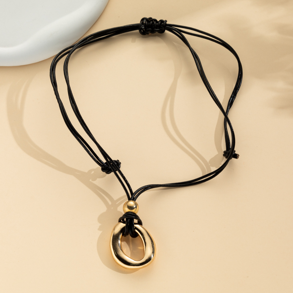 Irregular circle pendant on dark cord necklace