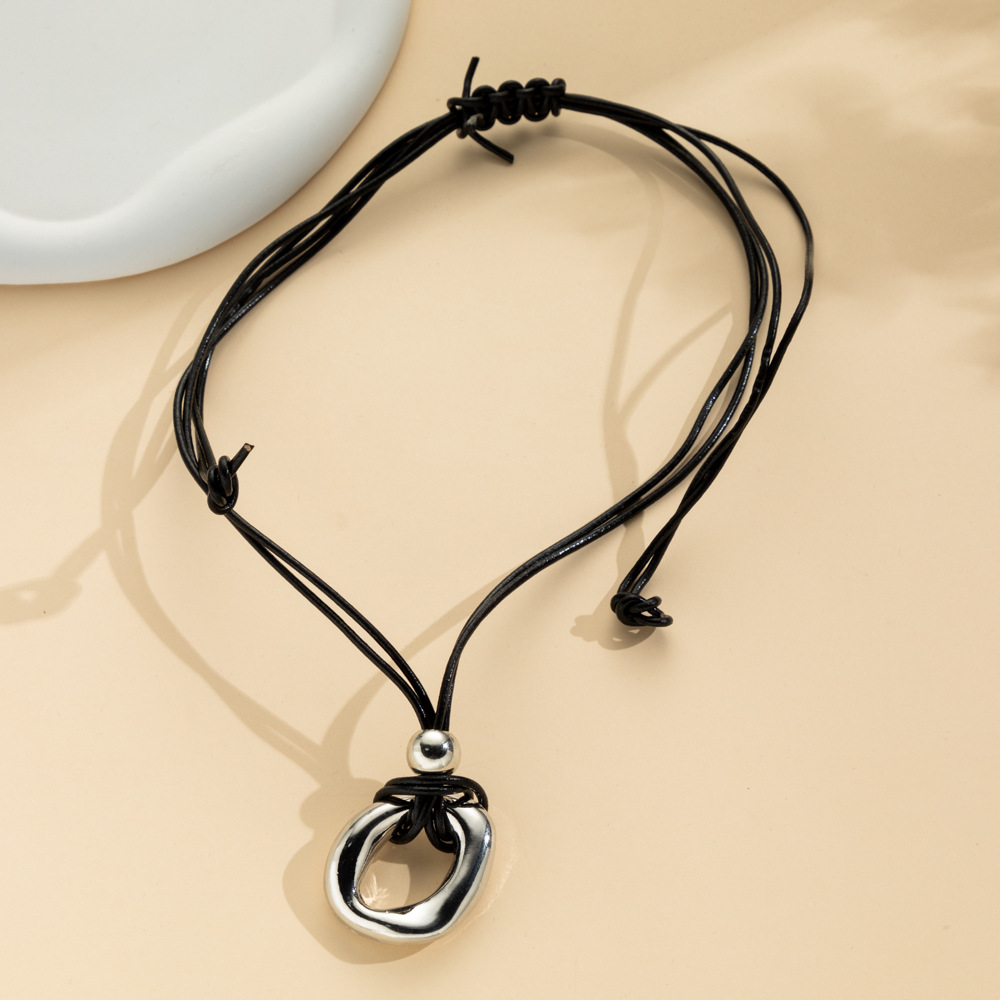 Irregular circle pendant on dark cord necklace