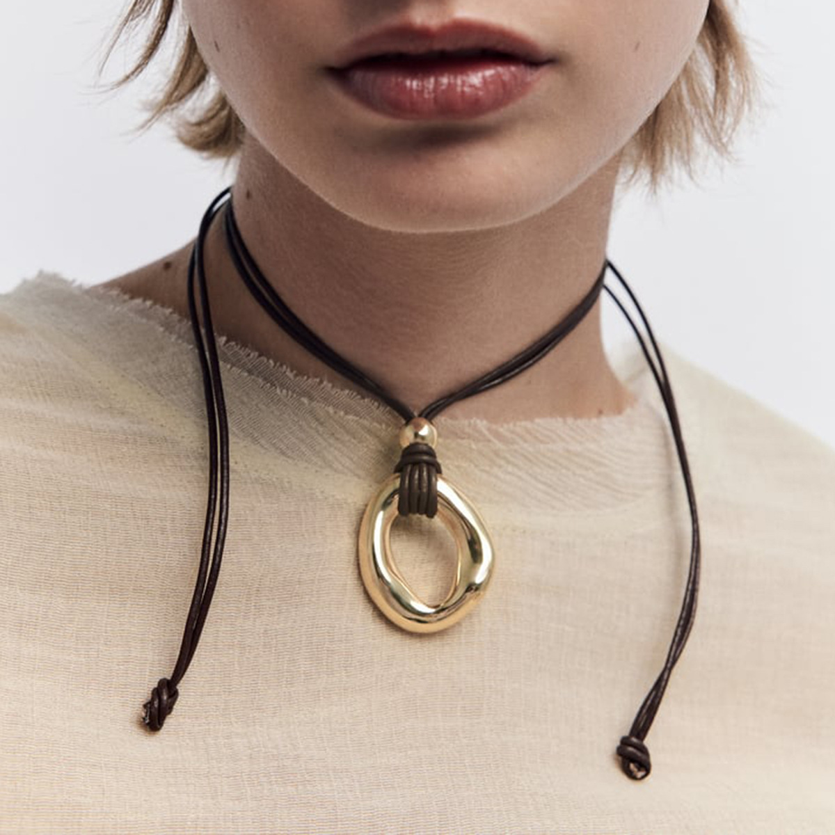 Irregular circle pendant on dark cord necklace