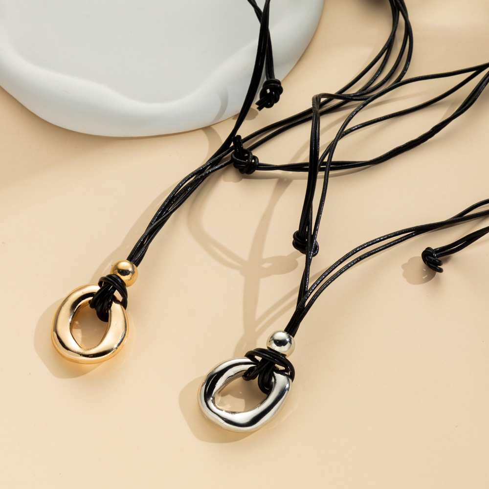 Irregular circle pendant on dark cord necklace